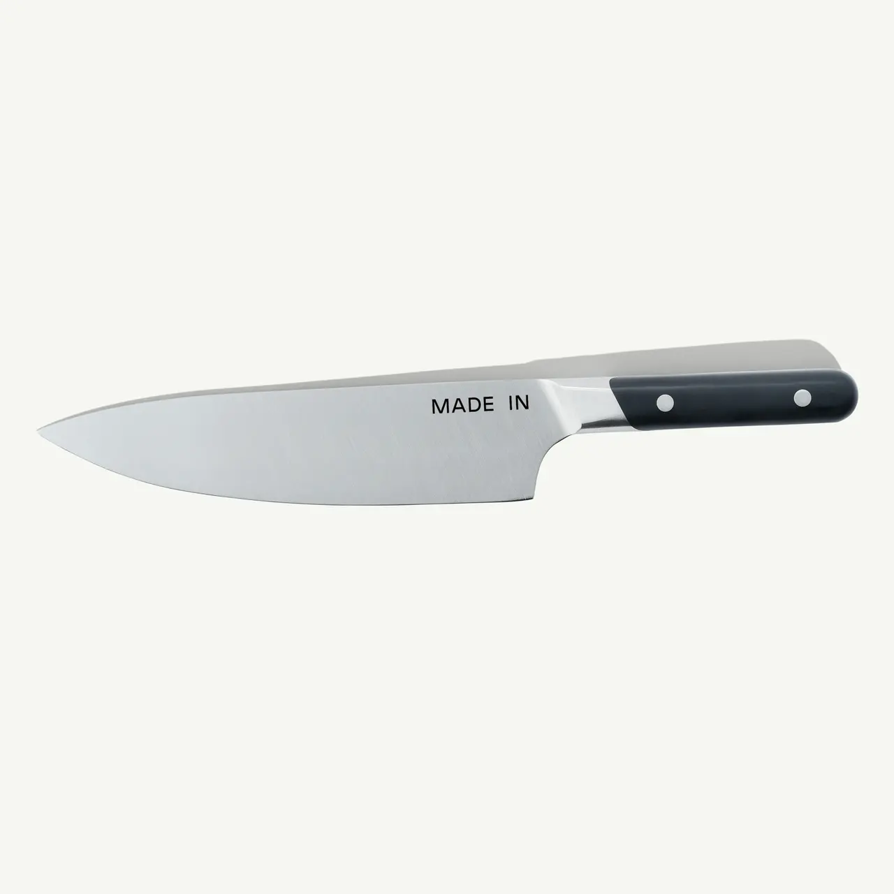 A stainless steel chef's knife with a black handle and "MADE IN" engraved on the blade.
