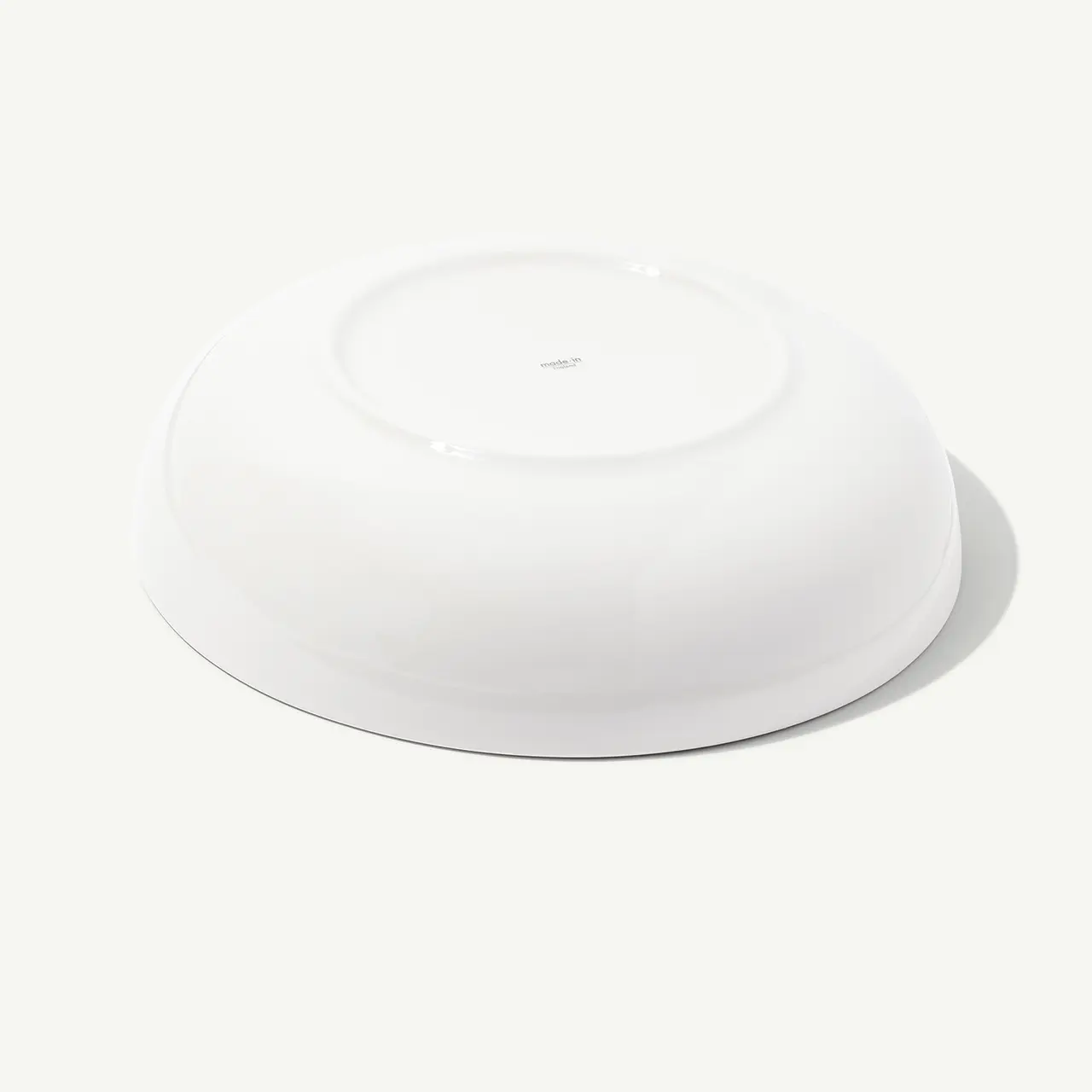 Upside-down white ceramic bowl on a plain background.